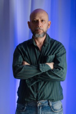 Kolları çaprazlanmış bir adam kameraya bakıyor. Stüdyo portresi. beyaz perde arkaplanı