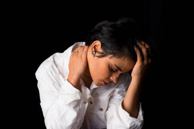 Young woman portrait in studio wearing white shirt. Isolated on black background.