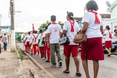 Salvador, Bahia, Brezilya - 07 Nisan 2023: Bahia 'nın başkenti Valenca' da İsa 'nın tutkusunun geçit töreni sırasında beyaz ve kırmızı giyinmiş Katolik inananlar geçidi.