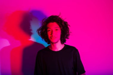 Fotografik arka planda renkli gölgeleri olan genç yakışıklı bir adamın portresi. rgb renkleri