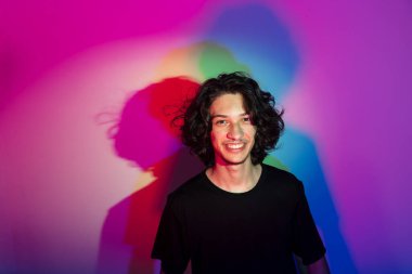 Fotografik arka planda renkli gölgeleri olan genç yakışıklı bir adamın portresi. rgb renkleri