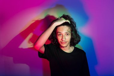 Fotografik arka planda renkli gölgeleri olan genç yakışıklı bir adamın portresi. rgb renkleri