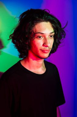 Fotografik arka planda renkli gölgeleri olan genç yakışıklı bir adamın portresi. rgb renkleri