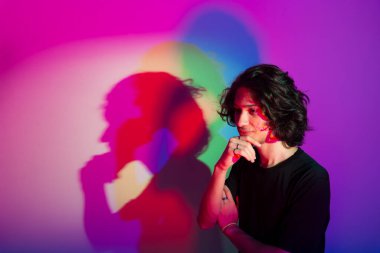 Fotografik arka planda renkli gölgeleri olan genç yakışıklı bir adamın portresi. rgb renkleri