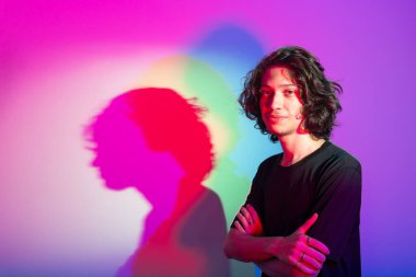 Fotografik arka planda renkli gölgeleri olan genç yakışıklı bir adamın portresi. rgb renkleri