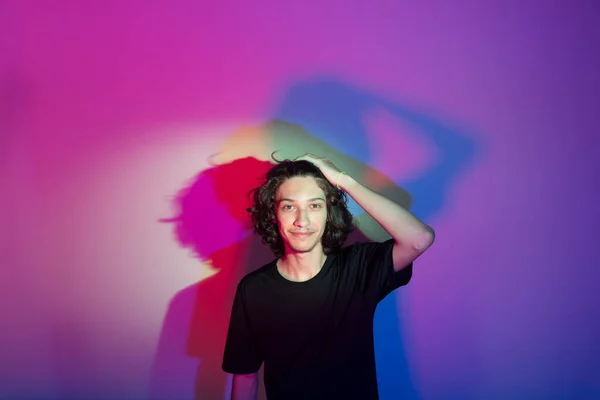 Stock image Portrait of young handsome man with colorful shadows on photographic background. rgb colors