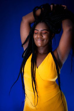Portrait of beautiful young woman with hands in her hair. Isolated on blue background.