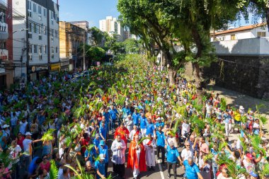 Salvador, Bahia, Brezilya - Abril 02, 2023: Katolik ibadet edenler, Salvador, Bahia 'daki Palm Sunday geçit töreninde palmiye dallarını sallıyorlar.