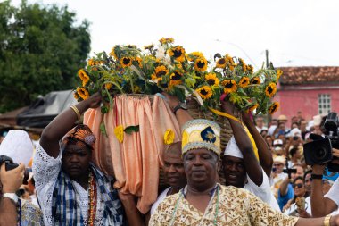 Santo Amaro, Bahia, Brezilya - 15 Mayıs 2022: Candomble üyeleri Bembe do Mercado kutlamaları sırasında Yemanja 'ya adak taşıyorlar. Itapema Plajı, Santo Amaro.