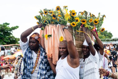 Santo Amaro, Bahia, Brezilya - 15 Mayıs 2022: Candomble üyeleri Bembe do Mercado kutlamaları sırasında Yemanja 'ya adak taşıyorlar. Itapema Plajı, Santo Amaro.