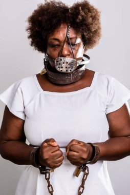 Yüzünde eski paslı zincirler ve maskeyle kapana kısılmış üzgün kadın portresi. Köle ticareti önleme kavramı.