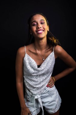 Siyah arka planda izole edilmiş beyaz elbiseli genç bir kızın stüdyo portresi..