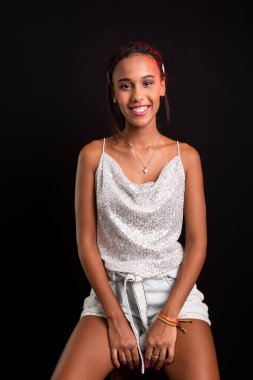 Genç kız portresi, gülümsüyor, kameraya bakıyor. Siyah arkaplanda izole.