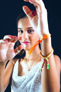 Kameraya el hareketi yapan güzel bir genç kızın stüdyo portresi. Siyah arkaplanda izole.