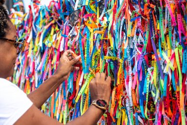 Salvador, Bahia, Brezilya - 06 Ocak 2023: Tapanlar, Salvador, Bahia 'daki Sinyor do Bonfim kilisesinin korkuluğuna renkli kurdeleler bağlıyorlar..