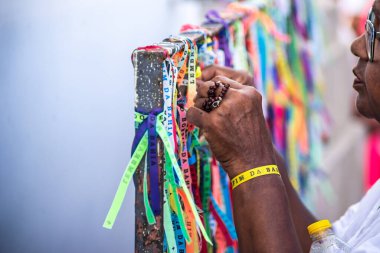 Salvador, Bahia, Brezilya - 06 Ocak 2023: Tapanlar, Salvador, Bahia 'daki Sinyor do Bonfim kilisesinin korkuluğuna renkli kurdeleler bağlıyorlar..