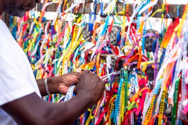 Salvador, Bahia, Brezilya - 06 Ocak 2023: Tapanlar, Salvador, Bahia 'daki Sinyor do Bonfim kilisesinin korkuluğuna renkli kurdeleler bağlıyorlar..