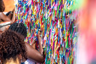 Salvador, Bahia, Brezilya - 06 Ocak 2023: Tapanlar, Salvador, Bahia 'daki Sinyor do Bonfim kilisesinin korkuluğuna renkli kurdeleler bağlıyorlar..