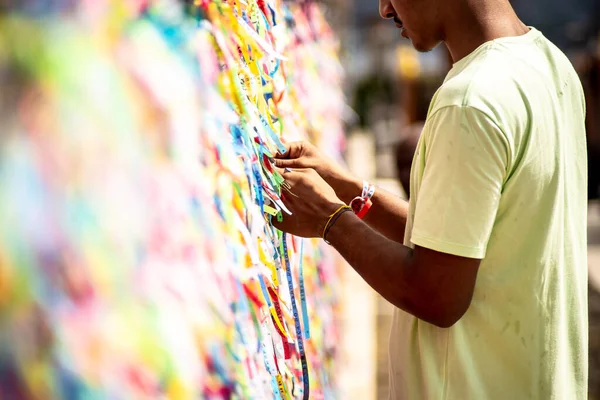 stock image Salvador, Bahia, Brazil - January 06, 2023: Worshipers are tying colored ribbons to the railing of the Senhor do Bonfim church on the first Friday of 2023, in Salvador, Bahia.