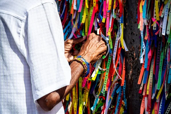 stock image Salvador, Bahia, Brazil - January 06, 2023: Worshipers are tying colored ribbons to the railing of the Senhor do Bonfim church on the first Friday of 2023, in Salvador, Bahia.