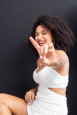 Güzel, genç bir kadın. Gri arka planda rahat ve mutlu. Stüdyo resmi