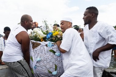 Santo Amaro, Bahia, Brezilya - 15 Mayıs 2022: Bembe do Mercado kutlamaları sırasında Iemanja 'ya adak taşıyan Candomble halkı. Itapema Plajı, Santo Amaro.