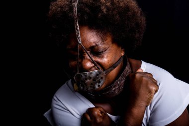 Yüzünde demir bir maske olan zincire vurulmuş siyah kadın köle Anastacia 'yı temsil ediyor. Acı ve ızdırap, işkence. Brezilya 'da kölelik.