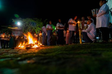 Valenca, Bahia, Brezilya - 08 Nisan 2023: Katolikler mumlarını yakmak için Cumartesi gecesi kutsal şenlik ateşinin etrafındalar. Valenca, Bahia 'da kutsal bir hafta.