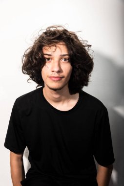 Beyaz arka planda gölgeli uzun saçlı yakışıklı bir adamın portresi..