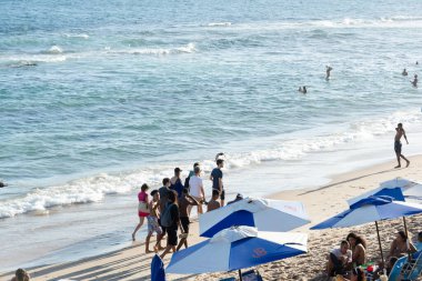 Salvador, Bahia, Brezilya - 22 Ekim 2022: Bahia 'nın Salvador kentindeki Farol da Barra plajında yürüyen insanlar.