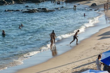 Salvador, Bahia, Brezilya - 22 Ekim 2022: İnsanlar Bahia 'nın Salvador kentindeki Farol da Barra plajında güneşleniyorlar..