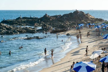 Salvador, Bahia, Brezilya - 22 Ekim 2022: İnsanlar Bahia 'nın Salvador kentindeki Farol da Barra plajında güneşleniyorlar..