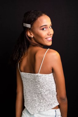 Genç bir kızın portresi, gülümseyen, güzel, beyaz elbiseler giyen. Siyah arkaplanda izole.