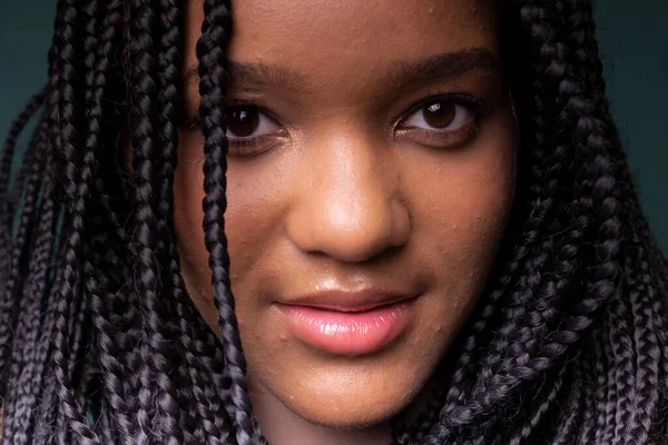 stock image Close-up portrait of beautiful young black woman with braided hair. Isolated on dark cyan background.