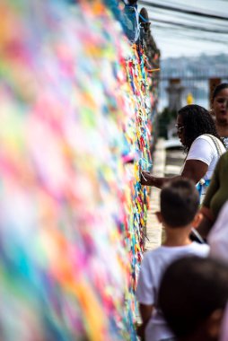 Salvador, Bahia, Brezilya - 06 Ocak 2023: Tapanlar, Salvador, Bahia 'daki Sinyor do Bonfim kilisesinin korkuluğuna renkli kurdeleler bağlıyorlar..