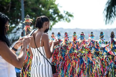 Salvador, Bahia, Brezilya - 06 Ocak 2023: Tapanlar, Salvador, Bahia 'daki Sinyor do Bonfim kilisesinin korkuluğuna renkli kurdeleler bağlıyorlar..