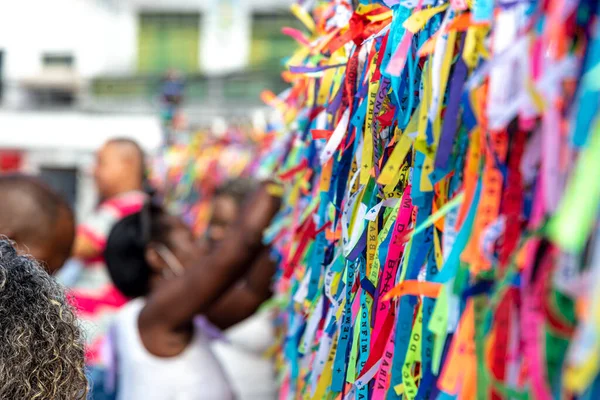 Salvador, Bahia, Brezilya - 06 Ocak 2023: Tapanlar, Salvador, Bahia 'daki Sinyor do Bonfim kilisesinin korkuluğuna renkli kurdeleler bağlıyorlar..