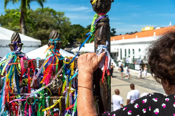 stock image Salvador, Bahia, Brazil - January 06, 2023: Faithful pray in front of the grid of the church of Senhor do Bonfim on the traditional first Friday of 2023, in Salvador, Bahia.