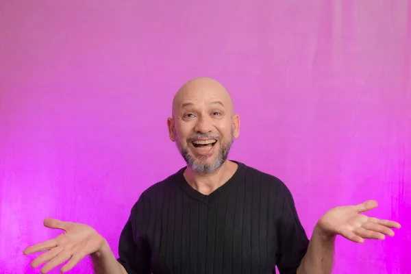 stock image Bearded and bald man making various signs with his hands. Isolated on pink background.