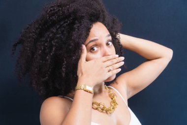 Güzel, genç bir kadın, komik ve güzel, elleriyle, ağzıyla ve gözleriyle çeşitli jestler yapıyor. Açık gri arkaplanda izole.