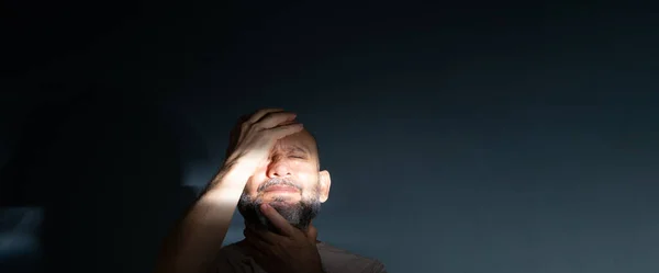 stock image Man in his 50s, emotionally shaken showing stress or pain gesture. Feeling weak or depressed. Isolated on dark background.