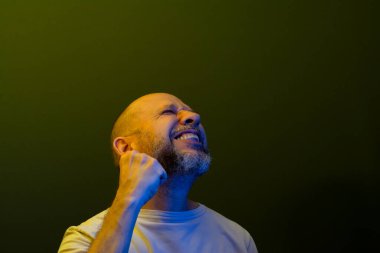 Mutlu, memnun, güç ve başarı gösteren bir adam. Başarı konsepti. Koyu yeşil arka planda izole edilmiş.