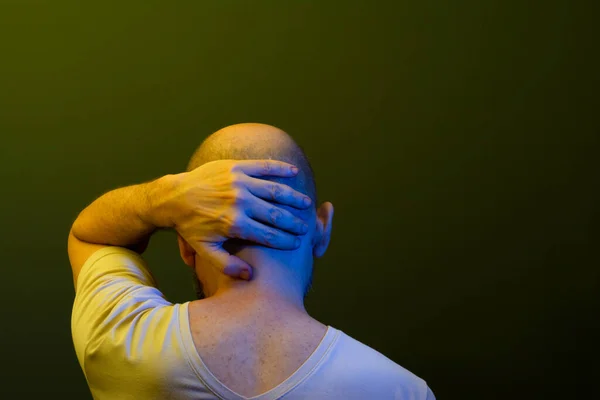 Stock image Man in his 50s, emotionally shaken showing stress or pain gesture. Feeling weak or depressed. Isolated on dark background.