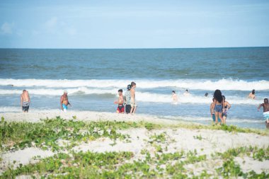 Valenca, Bahia, Brezilya - 27 Aralık 2022: İnsanlar Bahia 'nın Valenca kentindeki Guaibim plajında banyo yapıyor ve yürüyor.