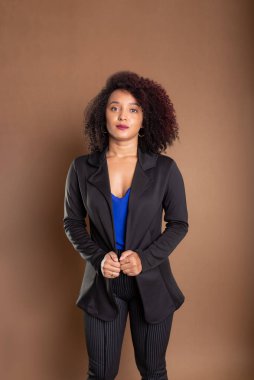 Genç iş kadını, zarif ve kendinden emin. Kahverengi arkaplanda izole.