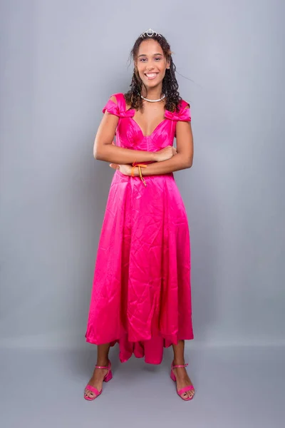 10代の女の子 美しく 幸せなピンクの色のドレスを着て立っている 灰色の背景に隔離された — ストック写真