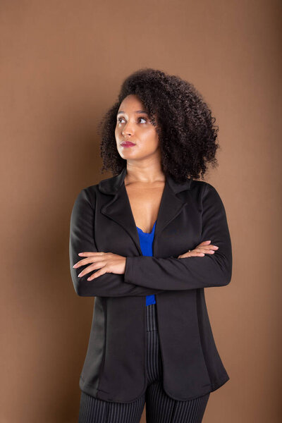 Young businesswoman, elegant and confident. Isolated on brown background.