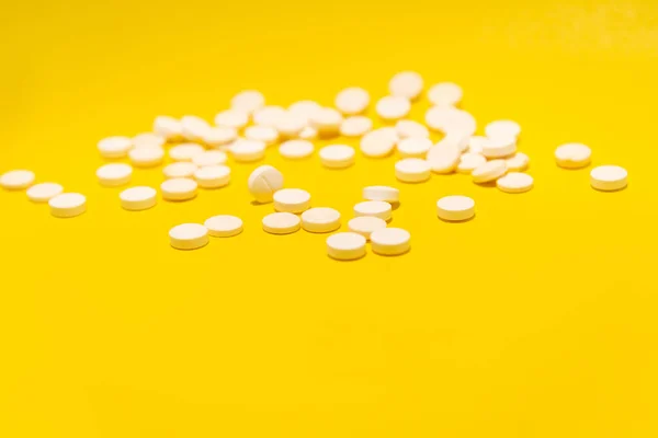 Několik Bílých Pilulek Umístěných Žlutém Povrchu Zdravotnické Potřeby — Stock fotografie