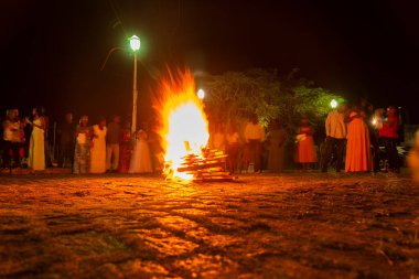 Valenca, Bahia, Brezilya - 08 Nisan 2023: Katolik inananlar cumartesi gecesi Noel Baba şenlik ateşinin etrafındalar. Valenca, Bahia 'da kutsal bir hafta.