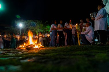 Valenca, Bahia, Brezilya - 08 Nisan 2023: Katolikler mumlarını yakmak için Cumartesi gecesi kutsal şenlik ateşinin etrafındalar. Valenca, Bahia 'da kutsal bir hafta.